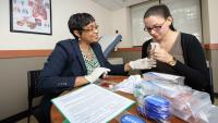 Two women sitting at a table with research materials.